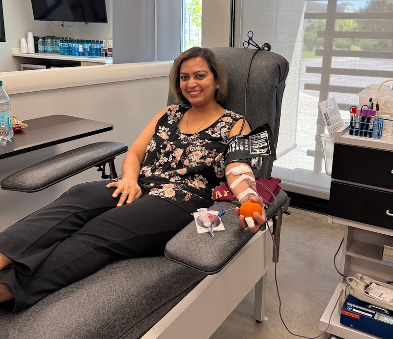 Image of Priyanka Marfatia sitting in a chair donating blood.
